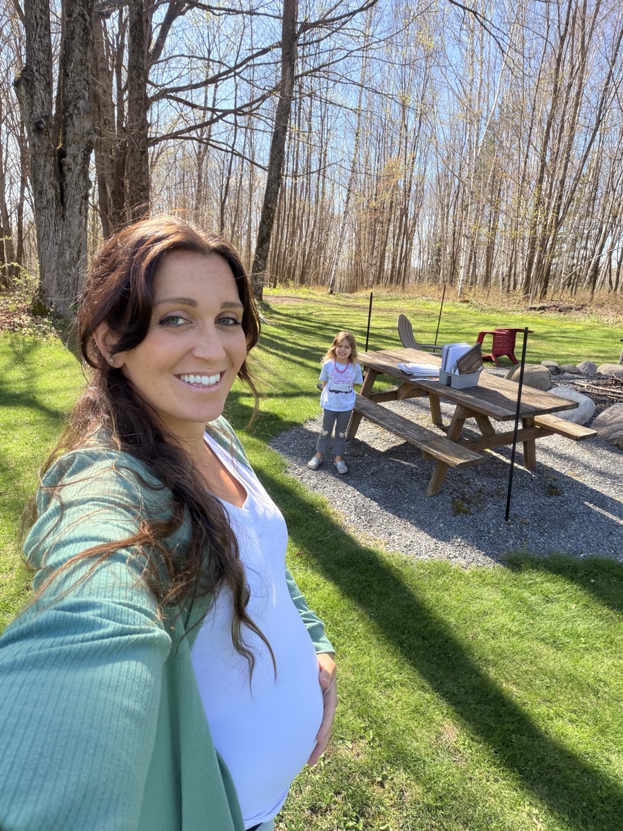 Rachel outside on a spring day with one of her children behind her