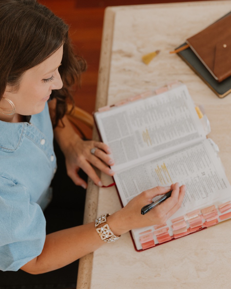 Rachel studying a well-worn, tabbed Bible with a pen in hand