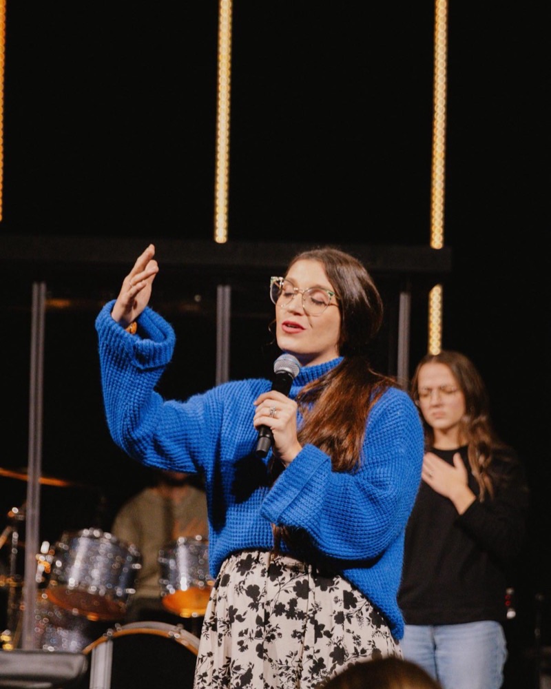 Rachel teaching from the stage with a microphone